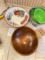 Overview of colander with silicone insert, wooden salad bowl, ceramic fruit bowl and wooden forks