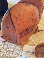 Left side close-up of carved wooden fish showing scale detail