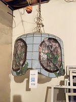 Full view of chandelier hanging showing shade design and chain