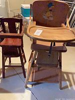 Overall view of both wooden high chairs showing finishes and styles