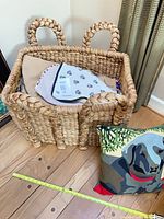 Overall view of wicker basket with pillow and measuring tape for scale