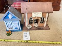 Two wooden birdhouses, measuring tape, animal figurines visible