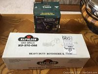 Closed boxes of Napoleon rotisserie kit and Intermatic outdoor timer on floor
