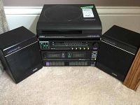 Front view of the closed Yorx Newave compact stereo record player system with both speakers flanking it.