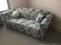 Full view of the double-sized sofa bed showcasing its shape, style, and upholstery pattern.