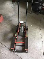 Top view of the hydraulic lift showing rubberized platforms, hydraulic pump, and handle base.