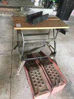 Black and Decker Workmate 400 wooden and metal collapsible workbench with two metal car ramps underneath and black plastic mitre box on top
