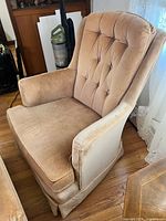 Tan tufted armchair showing upholstery and condition