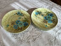 Stack of seven Prolon Beverly floral plates showing top decoration