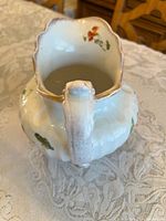 Side angled view showing jug shape, handle, rim, floral design