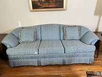 Front view of blue upholstered 3-seat sofa with pillows
