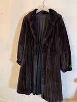 Full view of front of black mink fur coat on hanger