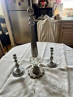 Candlesticks and glass statue on table