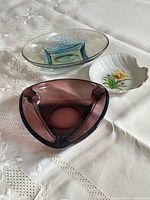 Three bowls including amethyst triangular glass, oval speckled art glass, porcelain shell dish