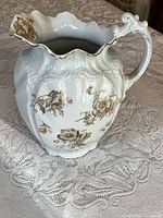 Full view of jug showing shape, floral pattern, rim and handle