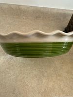 Side view showing ribbed green exterior and fluted white rim