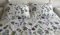 Comforter spread on bed with matching shams, close view of pattern