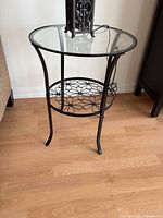 Front view of black metal and glass round end table