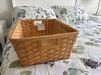 perspective view of rectangular woven wooden basket on bed
