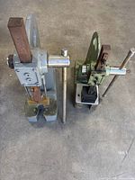 Top view of two manual arbor presses, grey and green, showing levers, rams and bases