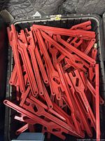Bin filled with multiple identical red aluminum gas and water shut-off wrenches