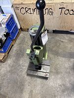 Full view of green manual lever press showing frame, lever and base