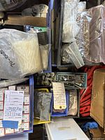 Overview of assorted fasteners in boxes and bags, including hex bolts, nuts, washers, screws, and zip ties