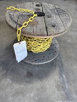 yellow powder-coated steel chain on wooden spool tagged as new