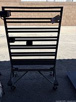 Full view of black metal Akro-Mils rolling rack with rail slots and casters