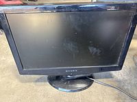 Front view of Dynex flat-panel TV on stand showing screen and bezel