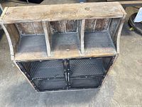 Front view showing three cubbies, lower mesh doors, wood and metal construction