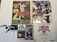 Group shot of newspaper, magazine, VHS tapes, figurine and promotional card
