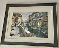 Front view of framed European village canal print with mats and gold frame