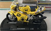 Left side profile of yellow Guiloy Ducati Supersport model on black base