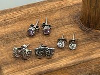 All three pairs of sterling stud earrings on wooden surface