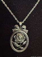 Close-up of pendant showing rose, marcasite border, bow bail