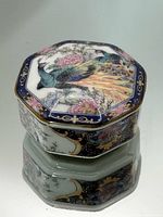 Full view of lidded octagonal porcelain box showing peacock and peony lid decoration and body panels