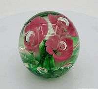 Front view showing pink flower inclusions and overall sphere shape