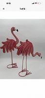 Both pink metal flamingo sculptures front view