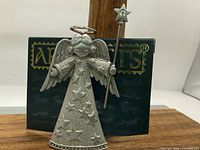 Front view of pewter angel brooch on Artifacts card