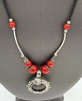 Front view of necklace on bust showing pendant, bead arrangement, and clasp area