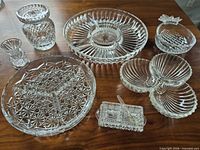 All seven pressed glass pieces and spoon displayed on tabletop