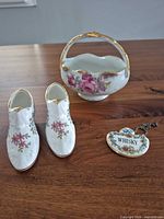 Top view of all items: two Paragon shoe figurines, Coalport bowl, whisky tag