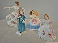 Group shot of all four Royal Doulton figurines standing together