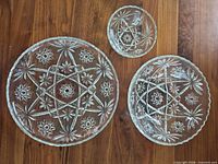 Top view of all three pressed glass pieces showing patterns and relative sizes