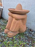 Front view of terracotta seated figure planter