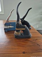 Three embossers on table: Buffalo Bill, Clarke & Stuart, blue chrome-handle unit