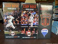Front view of three retail boxes for Cody Ross bobbleheads