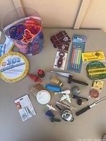 Overview of all kitchen gadgets, cookie cutter tub, thermometers, bottle opener, steamer and assorted tools