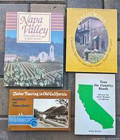 Four of six California travel guide books laid out: Napa Valley, Country Inns of America: California, Motor Touring in Old California, Tour the Country Roads
